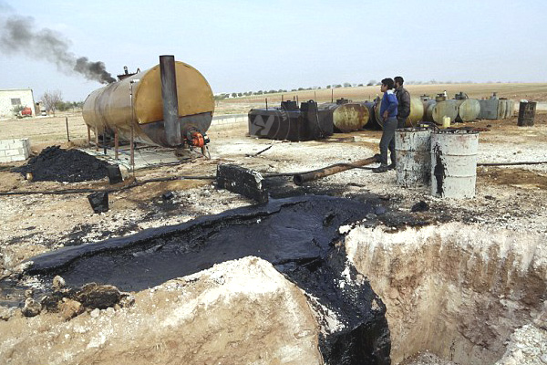 ISIS oil refinery men work.