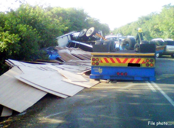 Lorry turns turtle with red sanders